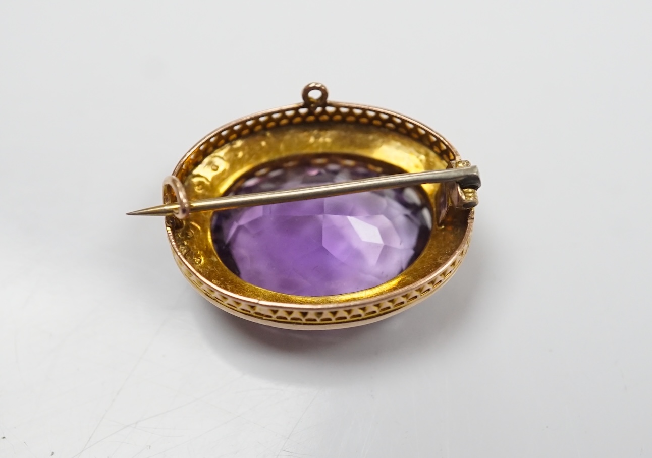 A mid 20th century 9ct and single stone oval cut amethyst set pendant brooch, with seed pearl border, 24mm, gross weight 4.8 grams. Condition - fair to good